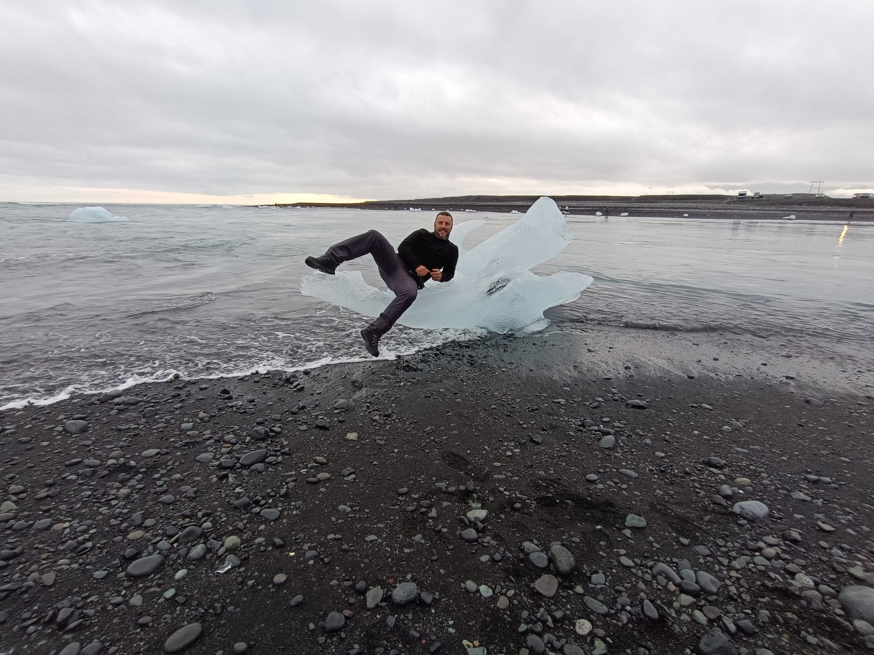 Enrique sobre un bloque de hielo en una playa de arena negra