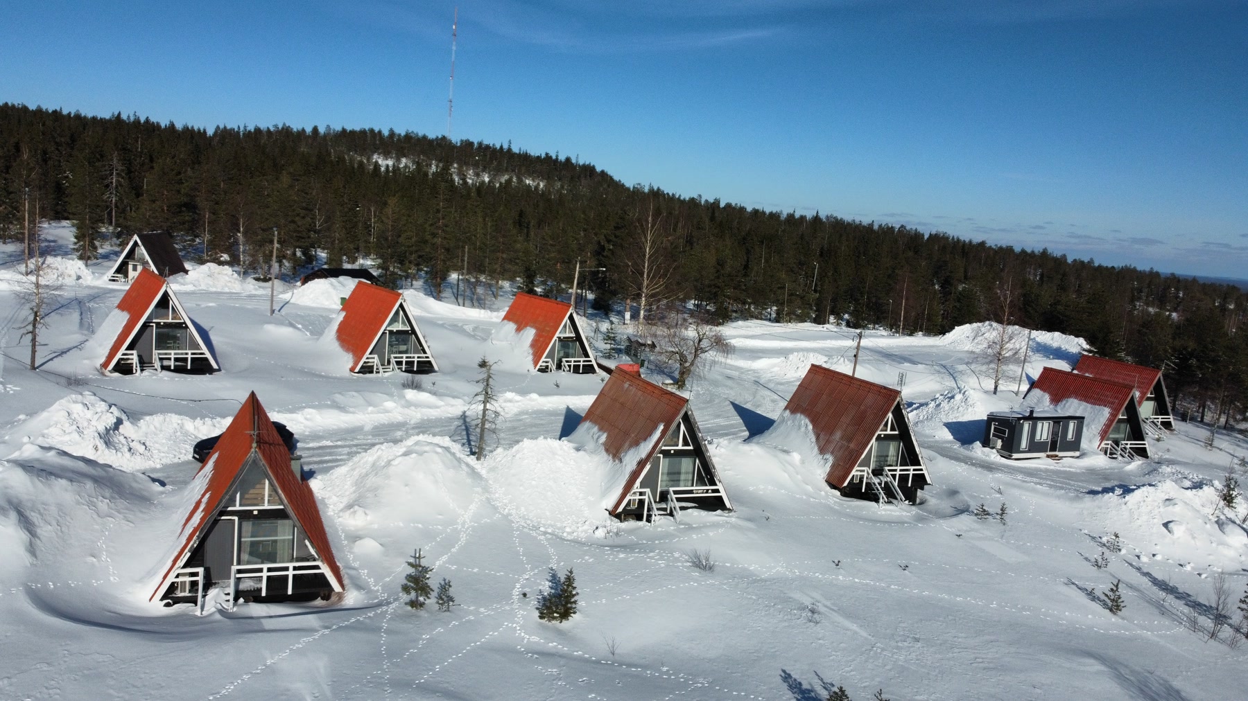 Cabañas triangulares de tejado rojo rodeadas de nieve