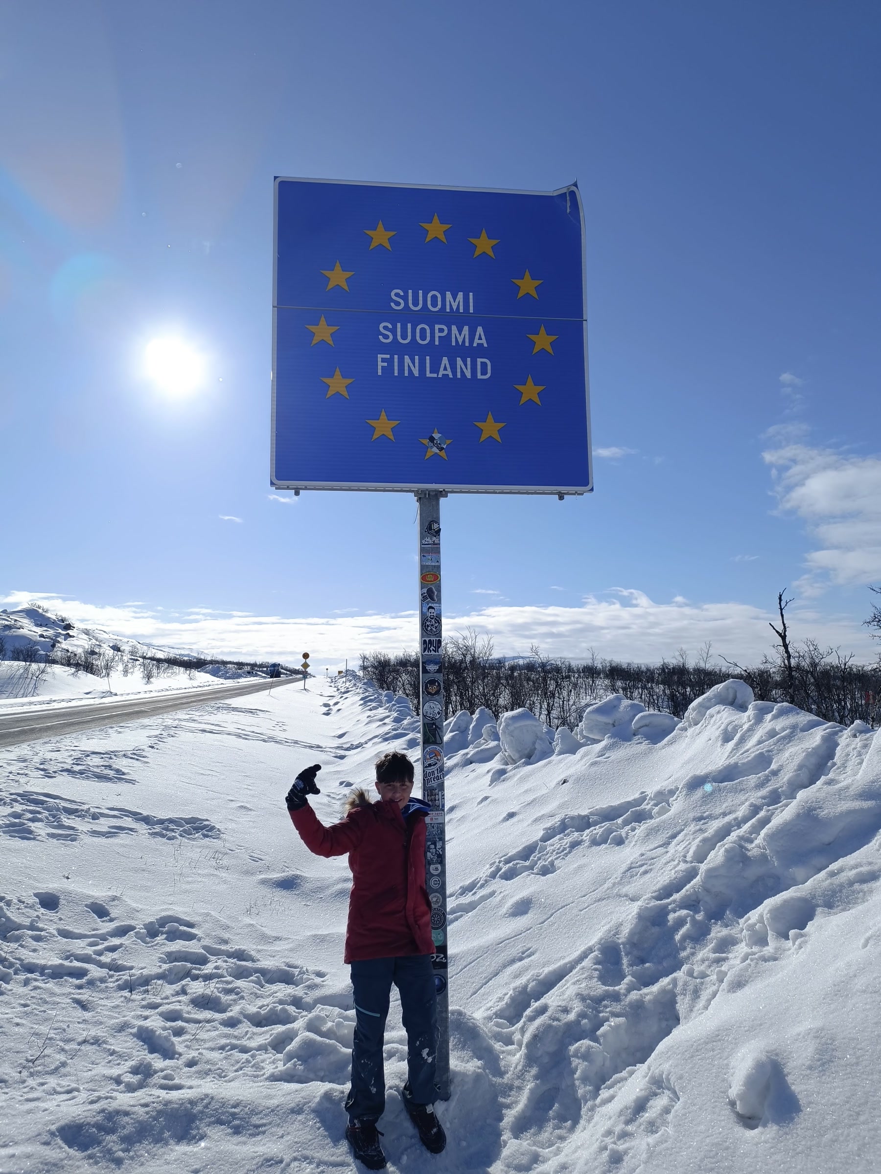 Cartel de entrada a Finlandia junto a una carretera nevada