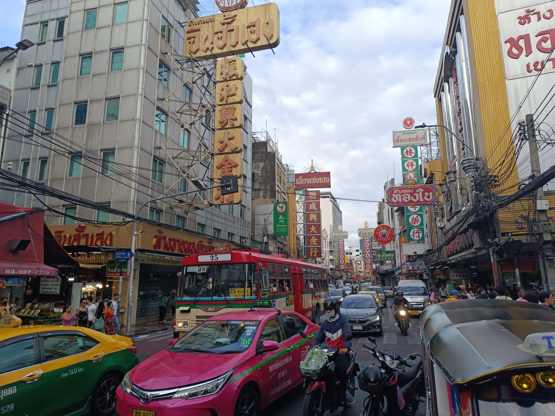 Yaowarat Road, el Chinatown de Bangkok, con carteles verticales en chino y tailandés sobre un atasco de taxis, motos y un autobús