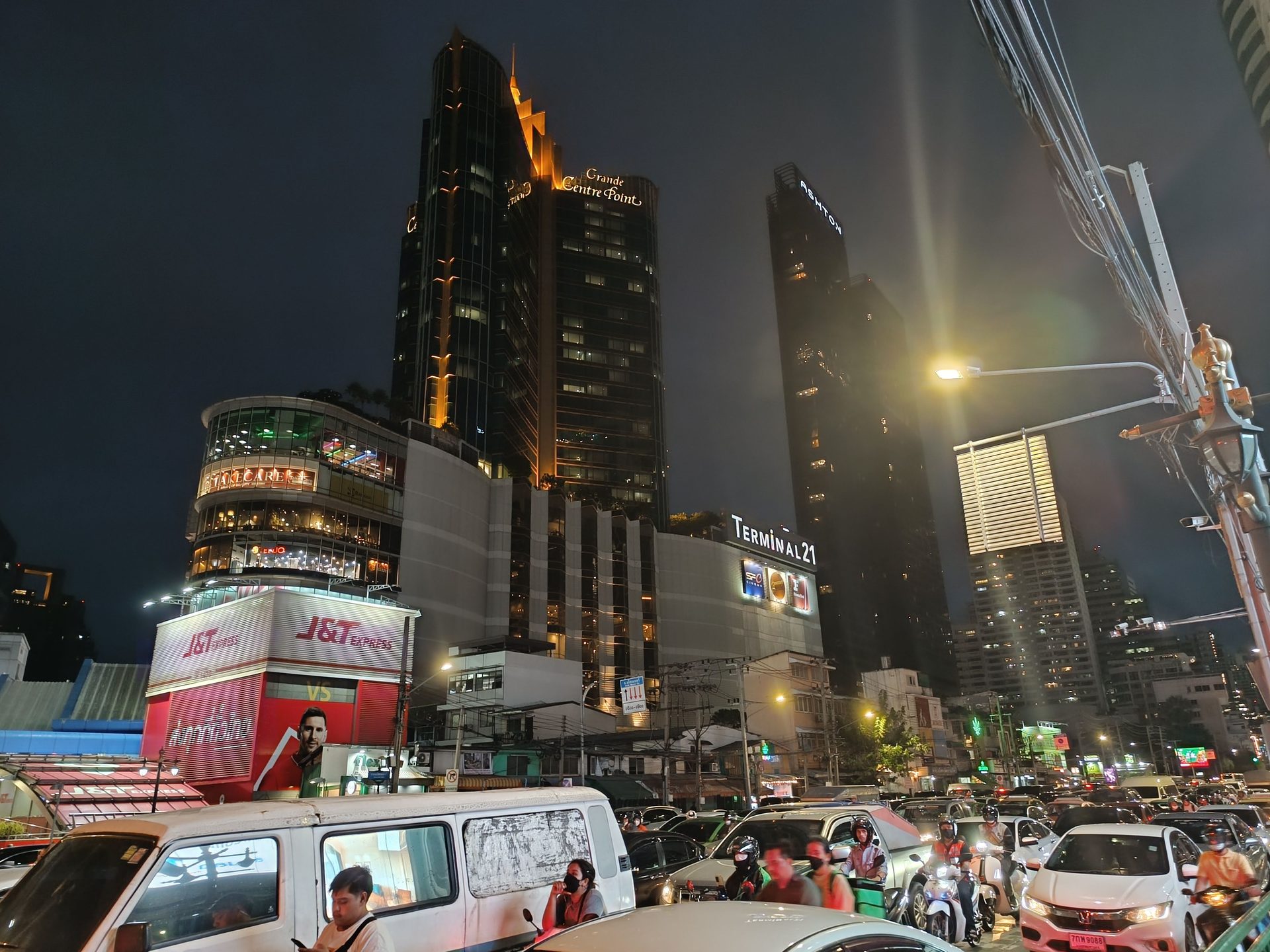 Rascacielos iluminados de Bangkok sobre un cruce lleno de coches y motos